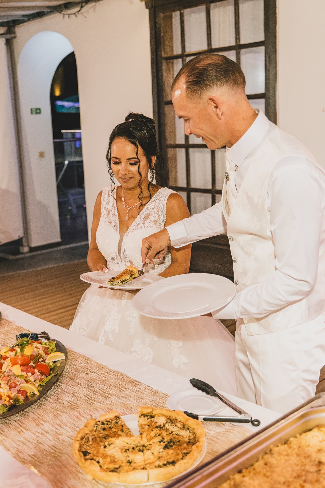Les mariés se servent au buffet de la réception